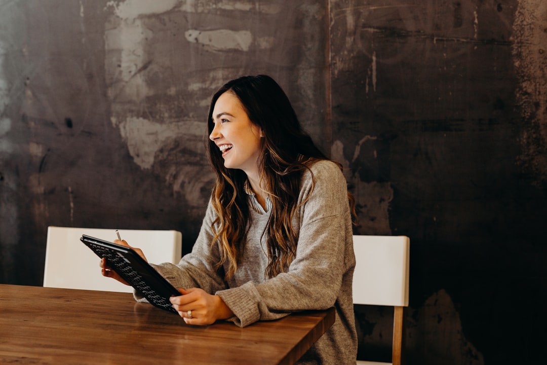 Photo by Brooke Cagle woman sitting around table holding tablet